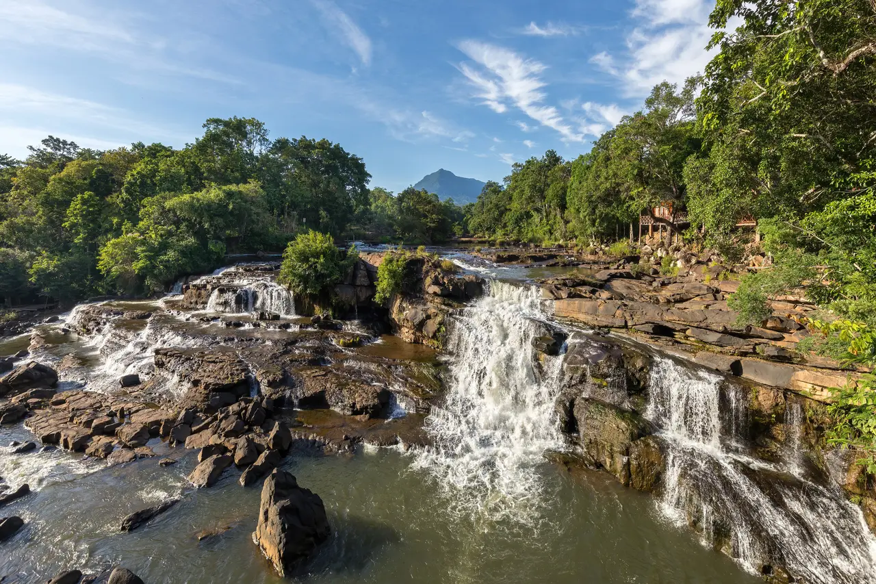 Tad Hang waterfall tumbling over wide rock steps in the early morning at Tad Lo village