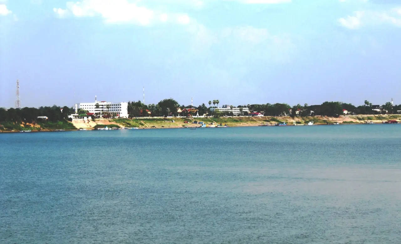 The wide Mekong River at Thakhek, with low buildings along the far bank
